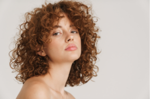 Half-naked ginger woman posing and looking at camera